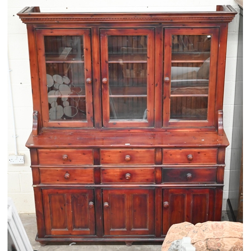 97 - A large stained pine dresser with glazed doors over six drawers and panelled cupboards in two sectio... 