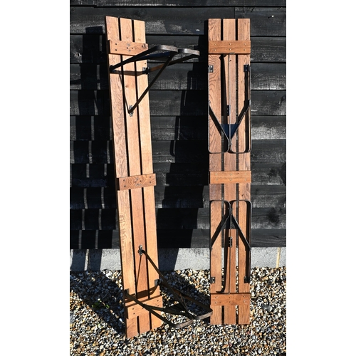 105 - A pair of slatted oak benches on folding metal supports, 178 cm wide