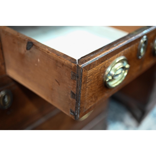 870 - An 18th century oak bureau cabinet, the upper part with pair of panelled doors enclosing shelves, th... 