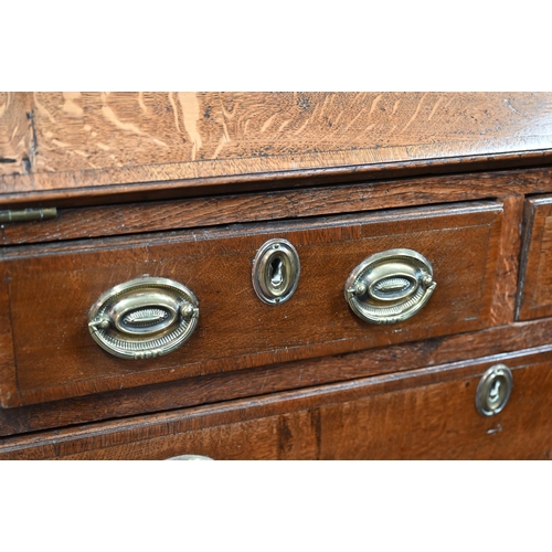 870 - An 18th century oak bureau cabinet, the upper part with pair of panelled doors enclosing shelves, th... 