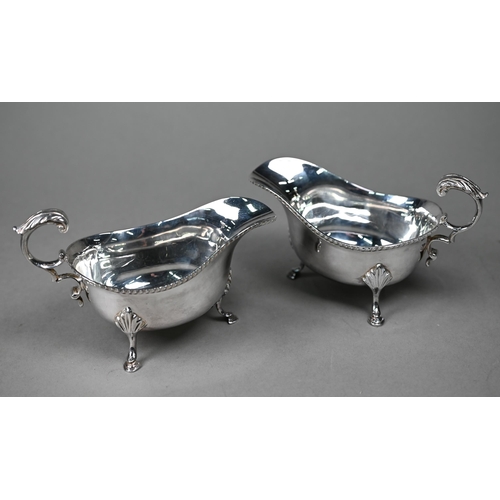 119 - A pair of silver sauce boats with gadrooned rims and scroll handles, on hoof feet, Roberts & Bel... 