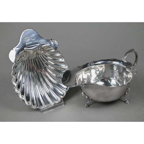 123 - A silver sauce boat in the Georgian manner, with cut rim, scroll handle and hoof feet, Birmingham 19... 