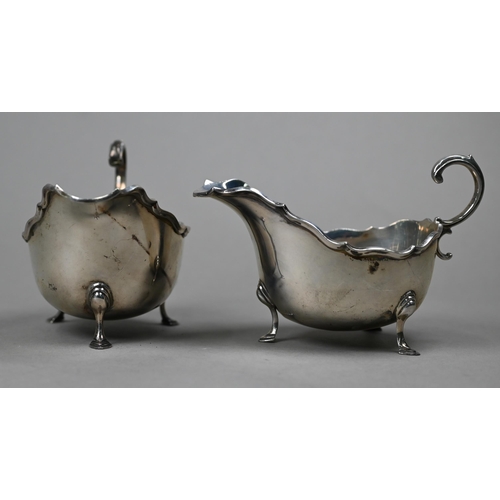 164 - A pair of silver sauce-boats with moulded rims and scroll handles, on hoof feet, Mappin & Webb, ... 