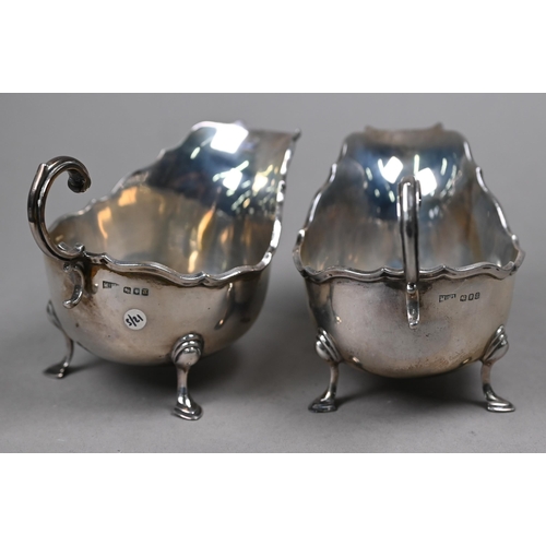 164 - A pair of silver sauce-boats with moulded rims and scroll handles, on hoof feet, Mappin & Webb, ... 