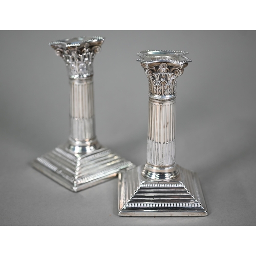 178 - A pair of late Victorian loaded silver candlesticks with reeded and fluted classical columns on step... 