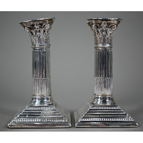 178 - A pair of late Victorian loaded silver candlesticks with reeded and fluted classical columns on step... 