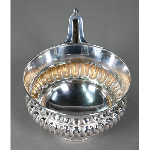 183 - A Victorian silver wine-cup with reeded and fluted waist and angular handle, on raised foot-rim, Hor... 