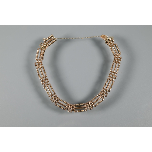 223 - A rose gold gatelink bracelet with concealed clasp and safety chain attached, stamped 15, approx 12.... 