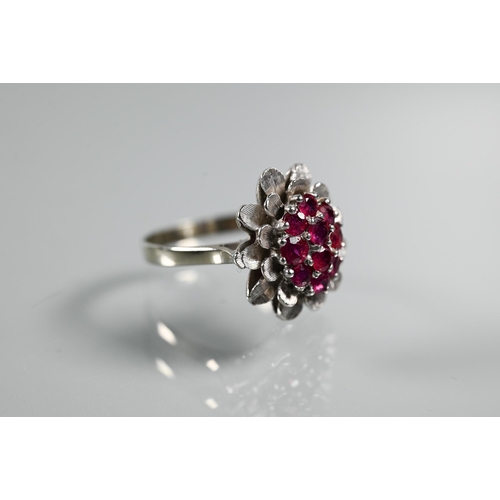 224 - A vintage cluster ring in the form of a flower set with rubies, size Q, 2cm diam