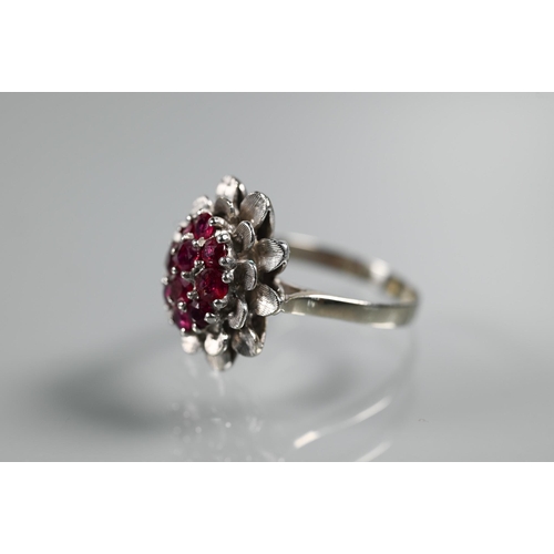 224 - A vintage cluster ring in the form of a flower set with rubies, size Q, 2cm diam