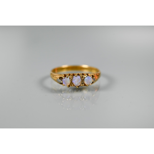 231 - A three stone ring set circular opals, yellow metal set stamped 18ct, size R