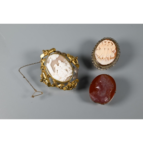 269 - A Victorian cameo brooch featuring a courting couple beneath a tree, in ornate gilt metal mount feat... 