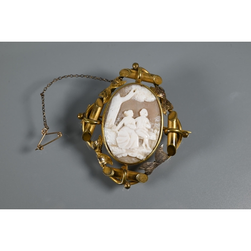 269 - A Victorian cameo brooch featuring a courting couple beneath a tree, in ornate gilt metal mount feat... 