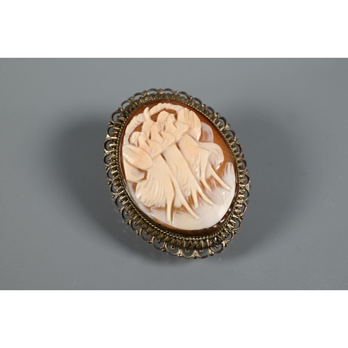 269 - A Victorian cameo brooch featuring a courting couple beneath a tree, in ornate gilt metal mount feat... 