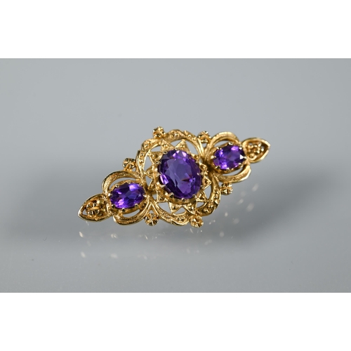 292 - A Victorian-style 9ct yellow gold brooch set with three oval amethysts in Gothic setting, 4 cm long,... 