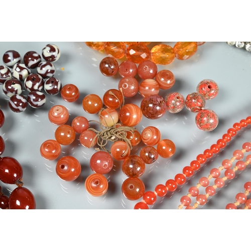 297 - A facetted orange amber graduated necklace, 54.1g; a cherry red amber graduated necklace, 50.4g; a r... 