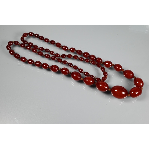 297 - A facetted orange amber graduated necklace, 54.1g; a cherry red amber graduated necklace, 50.4g; a r... 