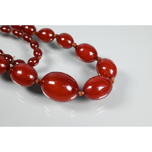 297 - A facetted orange amber graduated necklace, 54.1g; a cherry red amber graduated necklace, 50.4g; a r... 