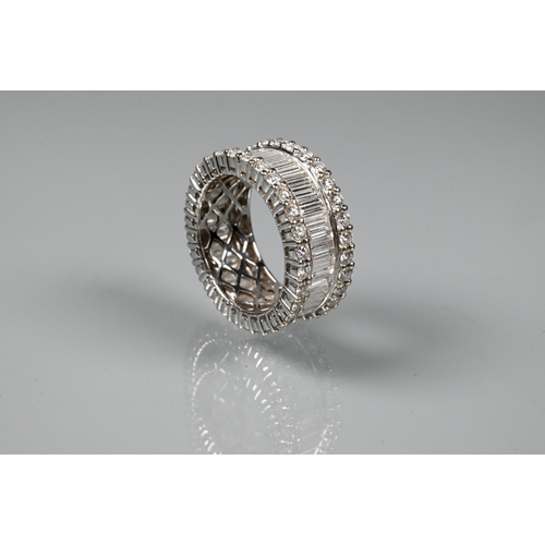 A contemporary diamond cluster eternity ring, the centre with a row of rectangular baguette-cut diamonds flanked by a row above and below of claw set brilliant cut diamonds, white gold stamped 750 18ct, size O, approx 8.2g all in