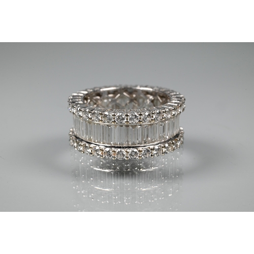 304 - A contemporary diamond cluster eternity ring, the centre with a row of rectangular baguette-cut diam... 