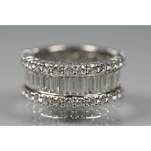 304 - A contemporary diamond cluster eternity ring, the centre with a row of rectangular baguette-cut diam... 