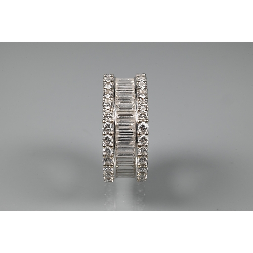 304 - A contemporary diamond cluster eternity ring, the centre with a row of rectangular baguette-cut diam... 