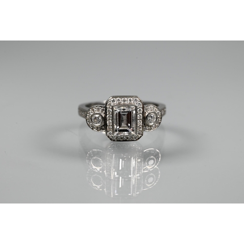 305 - An Art Deco style diamond-set cluster ring, the central rectangular diamond flanked by a collet set ... 