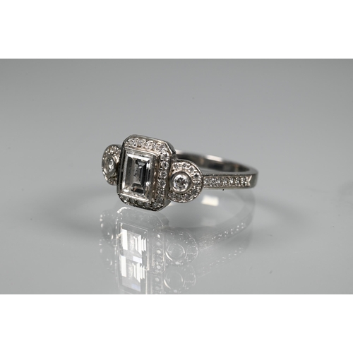 305 - An Art Deco style diamond-set cluster ring, the central rectangular diamond flanked by a collet set ... 