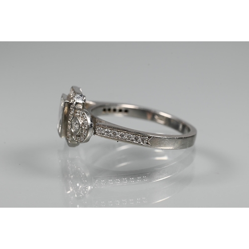 305 - An Art Deco style diamond-set cluster ring, the central rectangular diamond flanked by a collet set ... 