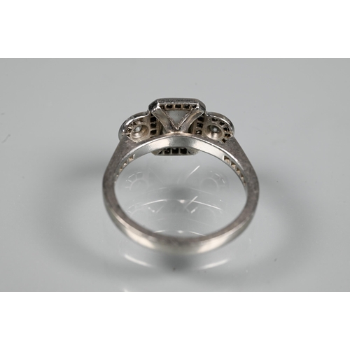 305 - An Art Deco style diamond-set cluster ring, the central rectangular diamond flanked by a collet set ... 