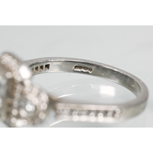 305 - An Art Deco style diamond-set cluster ring, the central rectangular diamond flanked by a collet set ... 