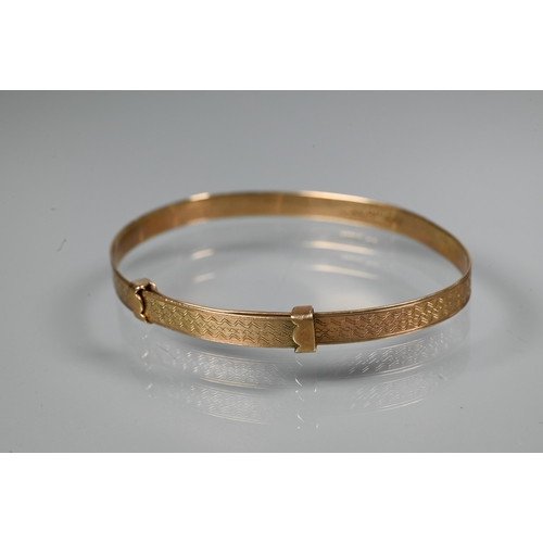 312 - A 9ct yellow gold expanding Christening bangle with engine turned decoration, size 6cm diam (max), a... 