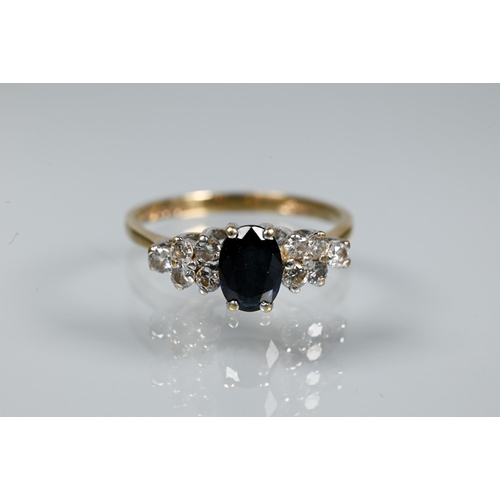 318 - A sapphire and diamond ring, the oval dark blue sapphire with five diamonds to each side, 9ct yellow... 