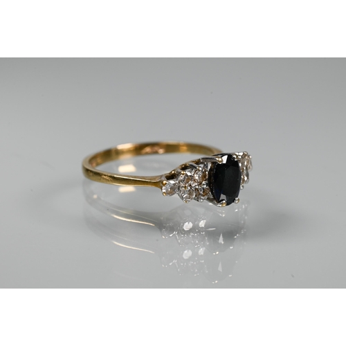 318 - A sapphire and diamond ring, the oval dark blue sapphire with five diamonds to each side, 9ct yellow... 