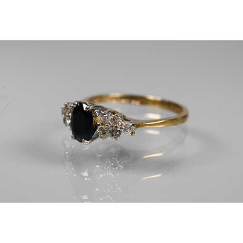 318 - A sapphire and diamond ring, the oval dark blue sapphire with five diamonds to each side, 9ct yellow... 