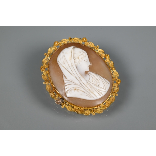 320 - A 19th century oval shell cameo featuring female with head scarf, with filigree yellow metal mount, ... 