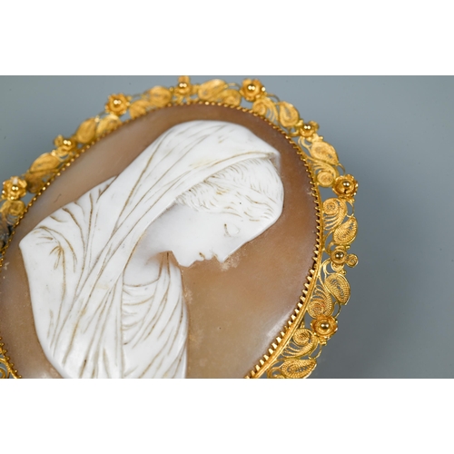 320 - A 19th century oval shell cameo featuring female with head scarf, with filigree yellow metal mount, ... 