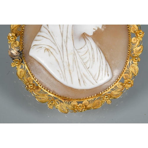 320 - A 19th century oval shell cameo featuring female with head scarf, with filigree yellow metal mount, ... 