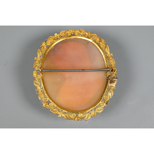 320 - A 19th century oval shell cameo featuring female with head scarf, with filigree yellow metal mount, ... 