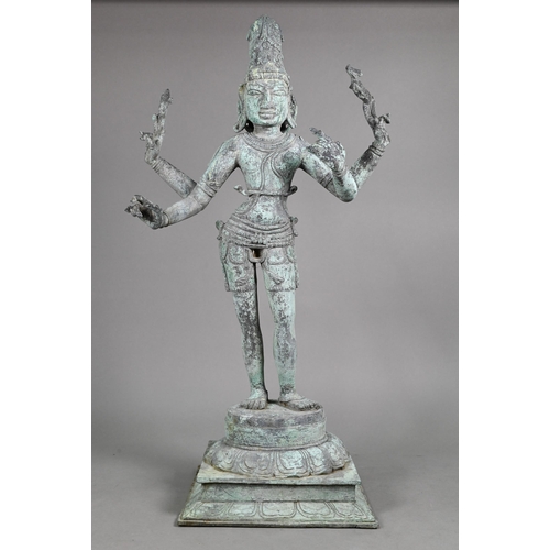 565 - A large Indian bronze figure of the Hindu deity Shiva standing on a stepped lotus base in the Chola ... 