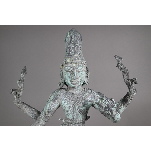 565 - A large Indian bronze figure of the Hindu deity Shiva standing on a stepped lotus base in the Chola ... 