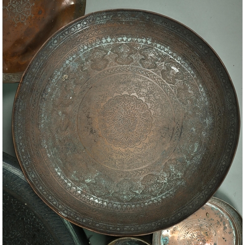 568 - A large Middle-Eastern engraved and embossed copper charger, 52 cm diameter, four various 19th centu... 