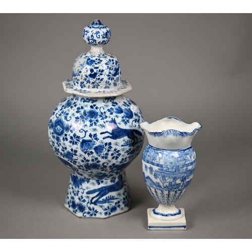 605 - An 18th century Delft blue and white vase and cover of octagonal baluster form, painted with wolves ... 