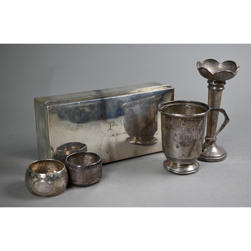 62 - A silver cigarette box, Sheffield 1919, to/w a Christening mug, two napkin rings, a weighted vase-fl... 