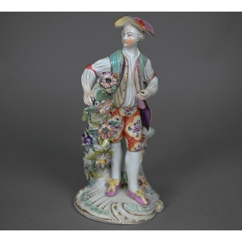 667 - An 18th century Derby porcelain figure of a young man in floral-painted breeches, 24 cm (restored)