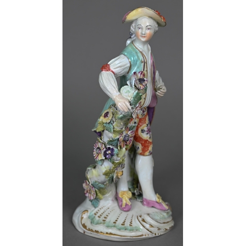 667 - An 18th century Derby porcelain figure of a young man in floral-painted breeches, 24 cm (restored)