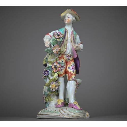 667 - An 18th century Derby porcelain figure of a young man in floral-painted breeches, 24 cm (restored)