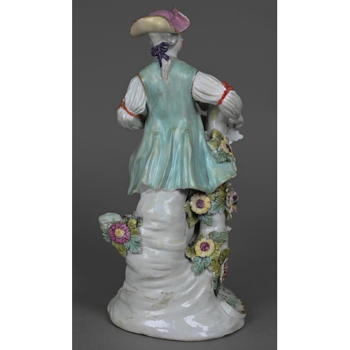 667 - An 18th century Derby porcelain figure of a young man in floral-painted breeches, 24 cm (restored)