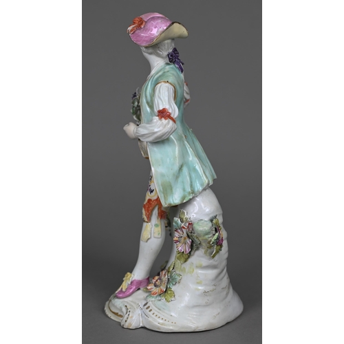 667 - An 18th century Derby porcelain figure of a young man in floral-painted breeches, 24 cm (restored)