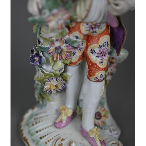 667 - An 18th century Derby porcelain figure of a young man in floral-painted breeches, 24 cm (restored)